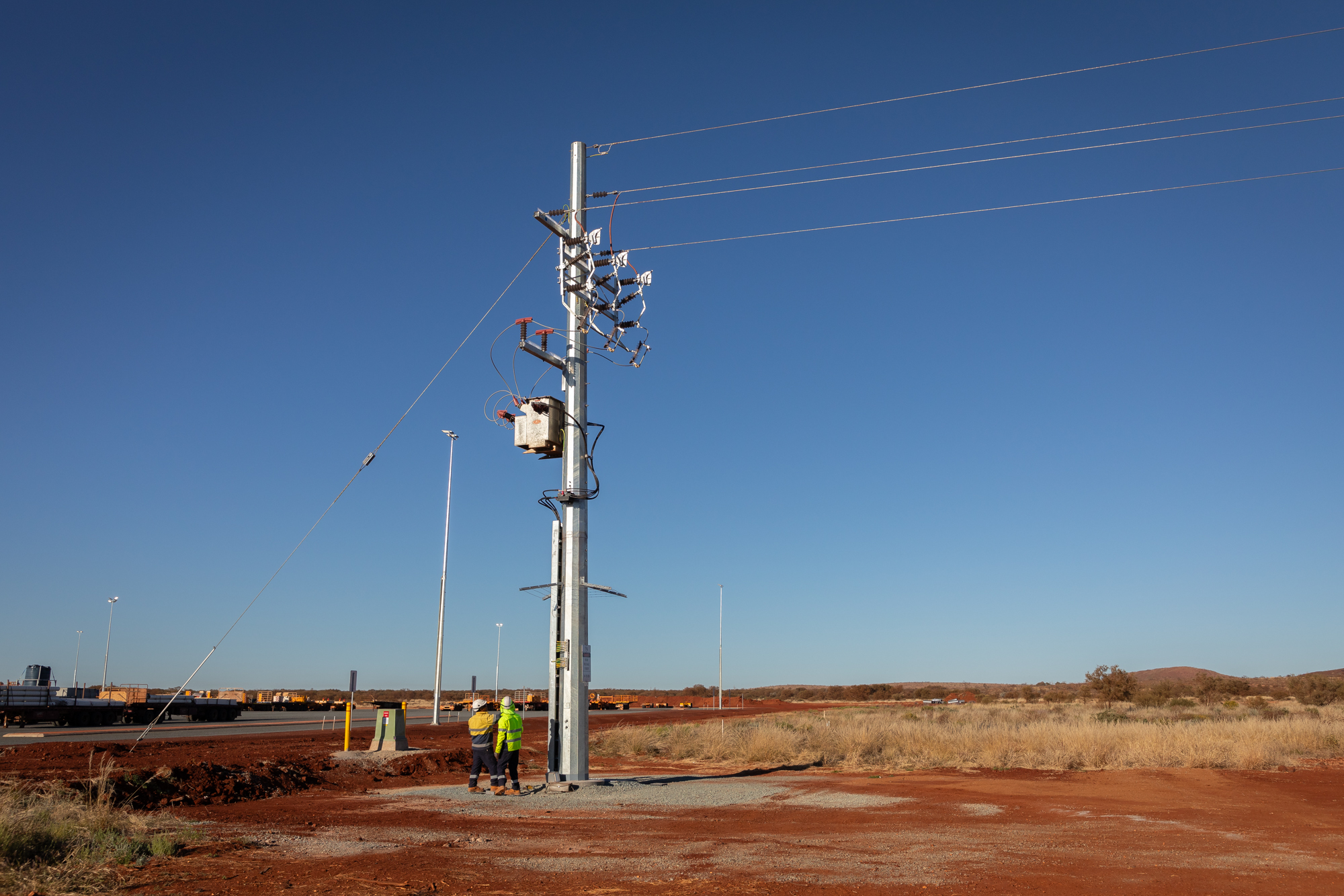two men standing looking at powerlines