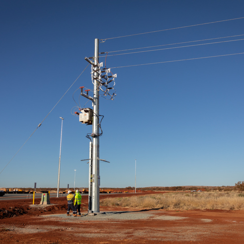 two men standing looking at powerlines
