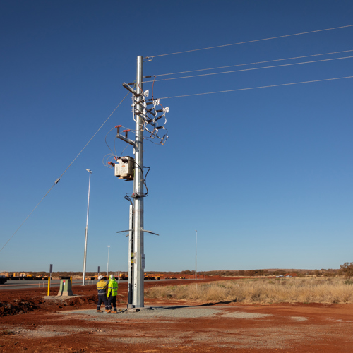 two men standing looking at powerlines